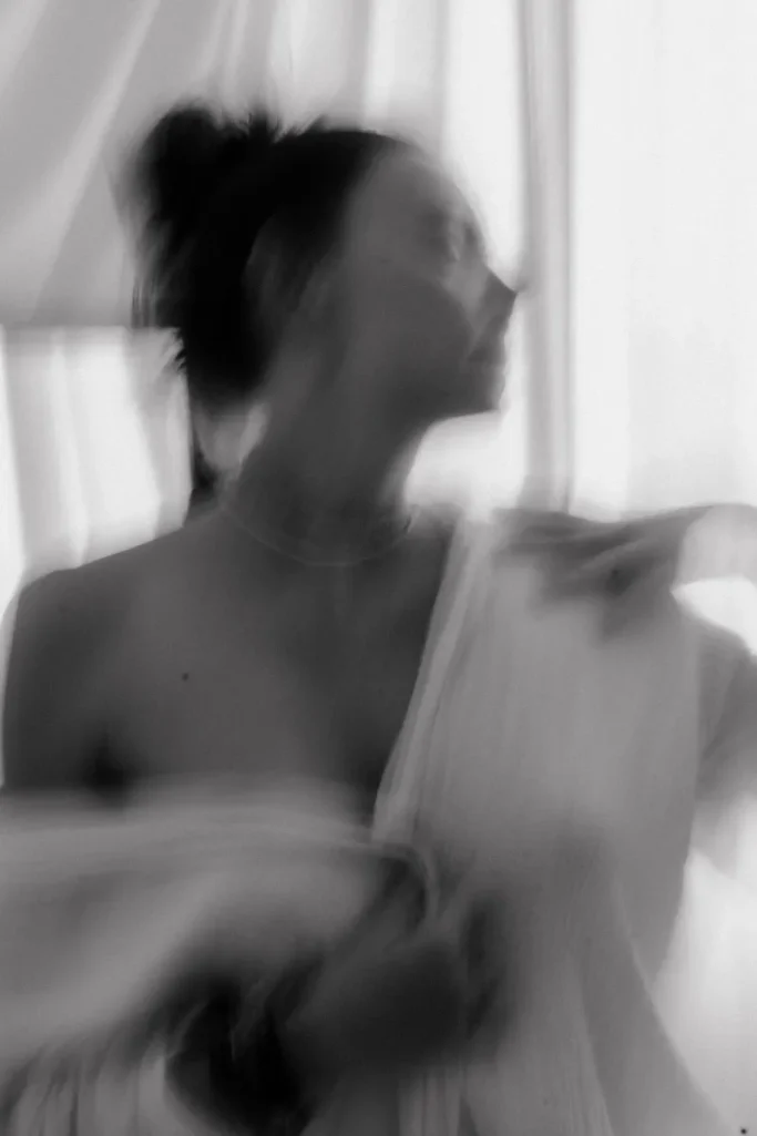 Natürliches Aktshooting in Münster Unscharfe Silhouette einer Frau, die sich in einem lichtdurchfluteten Raum bewegt.